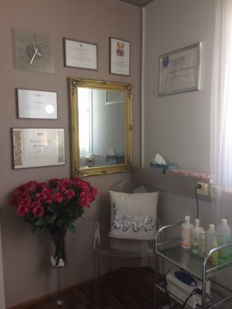 Beauty Studion hoitolan nurkkaus seinällä diplomit ja ruusukimppu